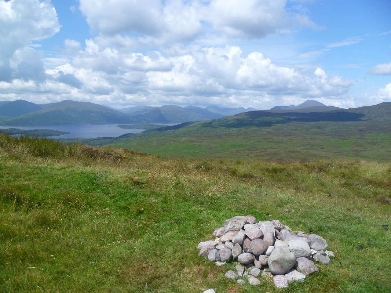 Open hillside vista from Conic Hill toward Loch Lomond under a bright sky—changeable hill conditions.