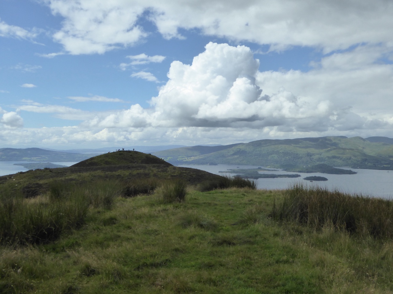 Summit ridge of Conic Hill with walkers and Loch Lomond’s islands beyond.