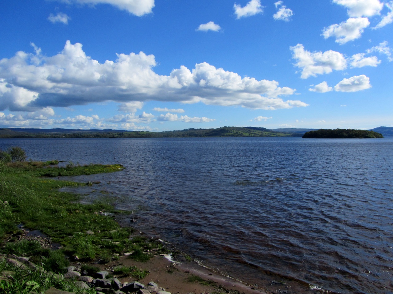 Loch Lomond from the shore at Balmaha, with a wooded island and hills beyond.
